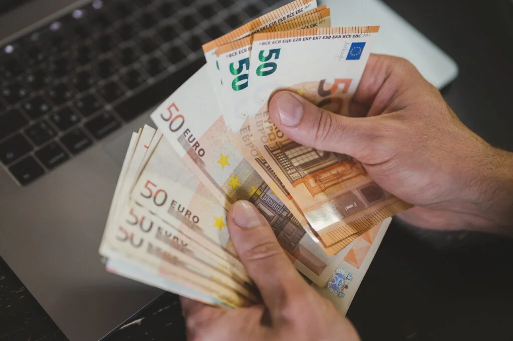 Mehrere 50€ Scheine vor einem Laptop